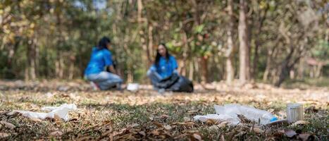 Garbage collect volunteer team collect up plastic bottles put garbage in garbage bags to clean up at parks avoid pollution be friendly to the environmental and ecosystem photo