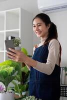 The concept of eco friendly housing, plant care and gardening. Relax home gardening. Gardener woman asian take a selfie with plant. Smiling woman takes care of plant photo