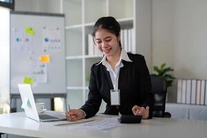 Businesswoman accountant using calculator and laptop for financial data saving in office room, Business financial, tax, accounting concept photo