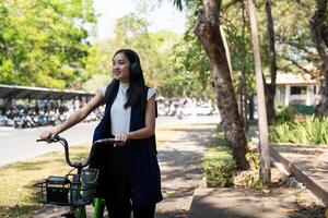 Eco friendly, Happy lifestyle asian beautiful young businesswoman riding bicycle go to office work at city street with bicycle in morning photo