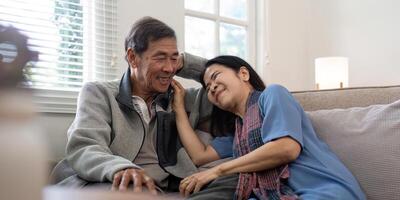 Happy mature husband and wife sit rest on comfortable sofa in living room enjoy talking, smiling elderly couple relax on couch at home chat speak laugh on leisure weekend photo