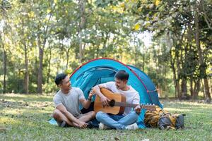 contento asiático masculino gay Pareja en cámping juntos en un bosque. romántico vocación viaje. lgbt concepto foto