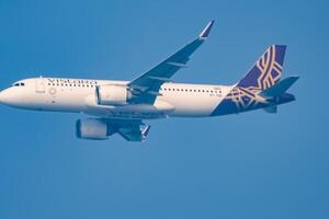 New Delhi, India, December 25 2023 - Vistara Airbus A320 neo take off from Indra Gandhi International Airport Delhi, Vistara domestic aeroplane flying in the blue sky during day time photo