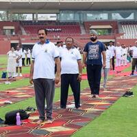 nuevo Delhi, India, junio 21, 2023 - grupo yoga ejercicio sesión para personas a yamuna Deportes complejo en Delhi en internacional yoga día, grande grupo de adultos asistiendo yoga clase en Grillo estadio foto