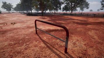 un' rustico rosso sporco campo con un' affascinante recinto e alberi nel il sfondo video