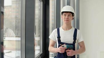 A wizard with a screwdriver in his hands is standing by the window. Front view video