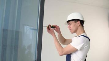 The wizard of installation of windows with a screwdriver screws screws in a window frame video