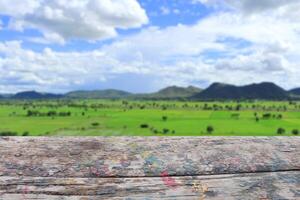 Old empty wooden table or terrace in front of the fields and mountains. photo