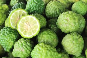 Bergamot or Kaffir lime. A citrus tree of southeast Asia with green fruit and aromatic leaves that are used in Thai cooking. It can also be used as an ingredient in shampoo or conditioner. photo