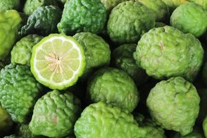 Bergamot or Kaffir lime. A citrus tree of southeast Asia with green fruit and aromatic leaves that are used in Thai cooking. It can also be used as an ingredient in shampoo or conditioner. photo