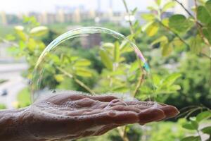 espuma de jabón en palmera. burbuja en mano. foto