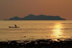 Silhouette of sea fisherman. photo