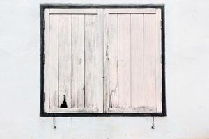 Old wooden window on white concrete wall. photo