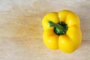 Sweet yellow pepper on wooden background. photo