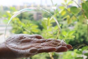 Soapsuds on palm. Bubble in hand. photo