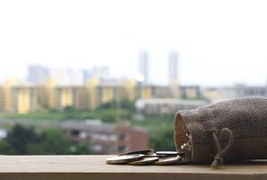 Money bag on wooden table on blurred of cityscape background. photo