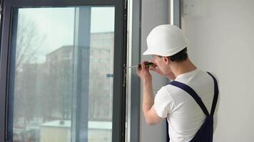 il procedura guidata di installazione di finestre con un' Cacciavite viti viti nel un' finestra telaio video