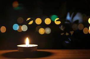 Candle on a wooden table on the balcony with bokeh backdrop. photo