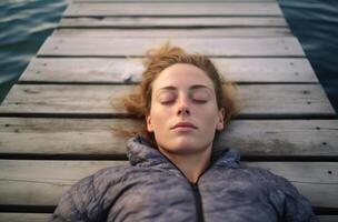 AI generated A woman sleeping peacefully on a boardwalk near a tranquil lake, sleep friendly urban environments, peaceful cityscapes, world sleep day serenity photo