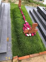 Muslim graves in Indonesia are decorated with manila grass plants and flowers photo