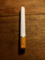 A filter cigarette on the wooden table photo