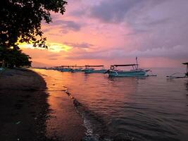 pescar barcos ancla en el playa en el tarde, cuando el puestas de sol foto