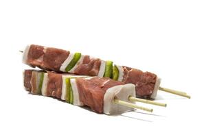 crudo carne y pimienta brochetas, aislado en un blanco antecedentes. generalmente un brocheta es hecho arriba de piezas de carne o pescado intercalado con cebolla, pimienta, hongos, etc. foto