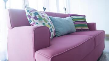 pink couch with colourful pillows photo