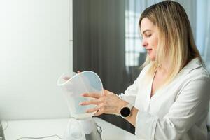 sick middle-aged woman breathing with inhaler portrait photo