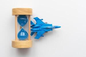 Expected time of arrival, flight delay and arrival concept. plane on hourglass with copy space for text photo