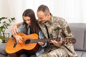 a veteran and his daughter play the guitar photo