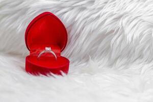 Diamond Ring in Heart-Shaped Box on fur white blanket. photo