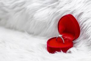 Diamond Ring in Heart-Shaped Box on fur white blanket. photo