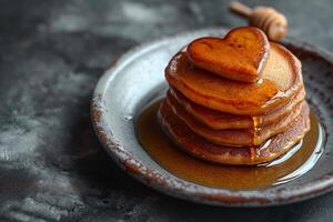 AI generated stack of heart-shaped pancakes with honey on a plate. View from above. Served on the kitchen table for breakfast photo
