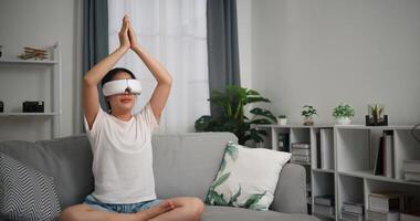 Selective focus, Relaxed young woman wear VR goggles meditating enjoying rest on sofa in living room at home, breathing fresh air, photo