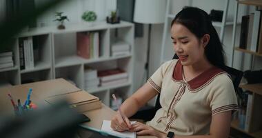 Selective focus, Side view,Female writer sitting at desk writing notes while working on tablet for online learning at home, creative thoughts to journaling, idea and inspiration photo