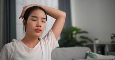 Selective focus, Happy young woman is practicing yoga and stretching her neck at home with eyes closed, relaxing body and mind alone on sofa in the living room,relaxation lifestyle photo