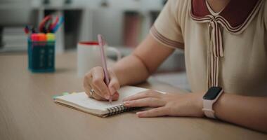 Selective focus, Hands of Female writer sitting at desk holding pen making notes in diary at home, creative thoughts to journaling, idea and inspiration photo