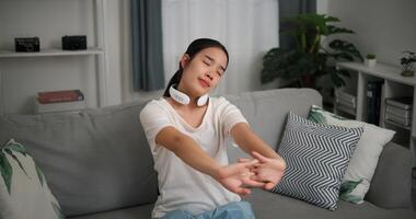 High angle view, Relaxed young woman wear automatic massage neck at home with eyes closed, relaxing body and mind alone in the living room, breathing fresh air, photo