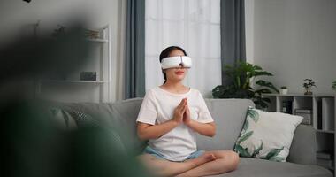 Selective focus, Relaxed young woman wear VR goggles meditating enjoying rest on sofa in living room at home, breathing fresh air, photo