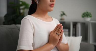 Selective focus, Relaxed young woman wear wireless headphones enjoying rest on sofa in living room, breathing fresh air with eyes closed, meditating at home photo