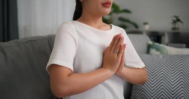 Selective focus, Young attractive woman sitting resting on sofa with eyes closed do meditation in the living room at home, deep relaxation practice, breathing fresh air photo