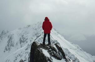 AI generated Man in red on a snowy mountain photo