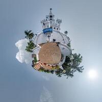 portugal catholic church in jungle among palm trees in Indian tropic village on little planet in blue sky, transformation of spherical 360 panorama. Spherical abstract view with curvature of space. photo