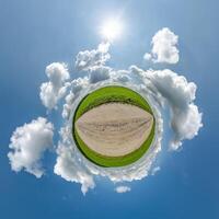 simple tiny planet without buildings in blue sky with beautiful clouds. Transformation of spherical panorama 360 degrees. Spherical abstract aerial view. Curvature of space. photo