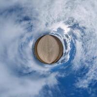 sencillo minúsculo planeta sin edificios en azul cielo con hermosa nubes transformación de esférico panorama 360 grados esférico resumen aéreo vista. curvatura de espacio. foto