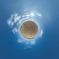 simple tiny planet without buildings in blue sky with beautiful clouds. Transformation of spherical panorama 360 degrees. Spherical abstract aerial view. Curvature of space. photo