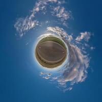 simple tiny planet without buildings in blue sky with beautiful clouds. Transformation of spherical panorama 360 degrees. Spherical abstract aerial view. Curvature of space. photo