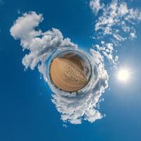 simple tiny planet without buildings in blue sky with beautiful clouds. Transformation of spherical panorama 360 degrees. Spherical abstract aerial view. Curvature of space. photo