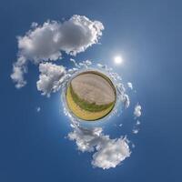 simple tiny planet without buildings in blue sky with beautiful clouds. Transformation of spherical panorama 360 degrees. Spherical abstract aerial view. Curvature of space. photo
